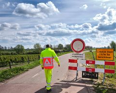 Verkeersregelaar en bord aan de dijk